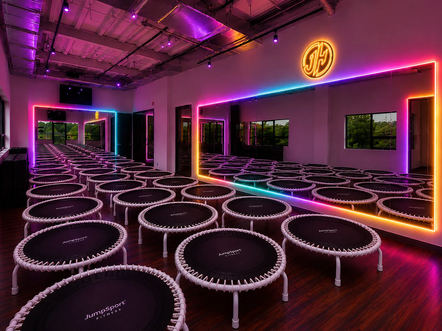 The JumpHaus studio with rows of rebounders and rainbow neon mirrors
