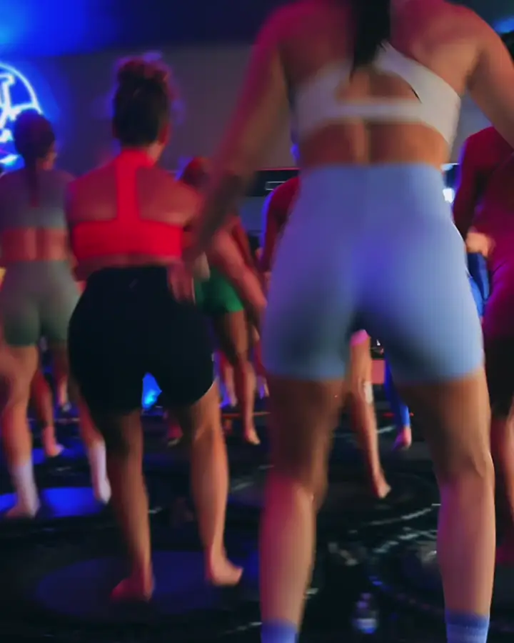 A packed rebound class bouncing under blue neon light